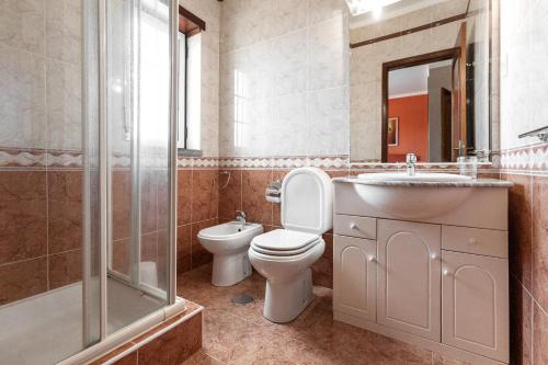 een badkamer met een toilet, een wastafel en een douche bij Ocean Breeze Villa in Atouguia da Baleia