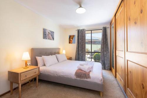 a small bedroom with a bed and a window at Kangaroo Pause -Home with yard & parking -Free wine in Hope Valley