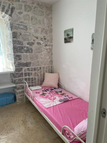 a small bed in a room with a brick wall at Luxury 6 bedroom house on waterfront in Perast