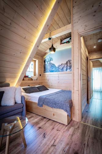 a bedroom with a bed in a wooden cabin at Domek Góralski - Górski HYR in Zakopane