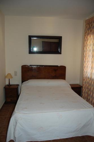 a bedroom with a large bed with a wooden headboard at Casa Rural Consuelo in Jumilla