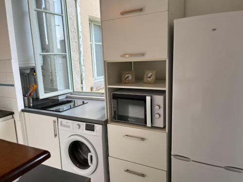 une cuisine avec un lave-linge et un micro-ondes dans l'établissement La charmante du Palais 2 chambres, à Avignon
