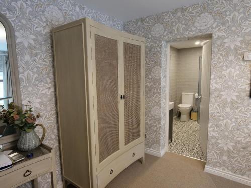 a bathroom with a toilet and a large cabinet at Oranmore in Ballymena