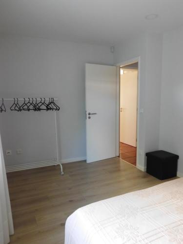 a white room with a bed and a door at Casa da Veiga in Lago
