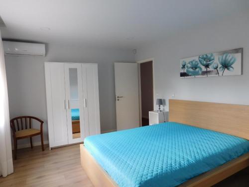 ein Schlafzimmer mit einem Bett mit einer blauen Decke in der Unterkunft Casa da Veiga in Lago