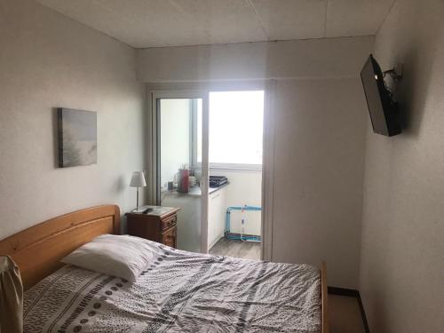 - une chambre avec un lit et une télévision murale dans l'établissement Vue sur mer proche de st jean de monts, à Saint-Hilaire-de-Riez