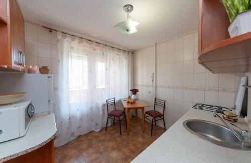 a kitchen with a table and chairs and a sink at Затишна квартира в центрі Оболоні м Київ in Kyiv
