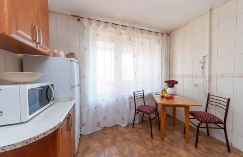 a kitchen with a table with chairs and a microwave at Затишна квартира в центрі Оболоні м Київ in Kyiv
