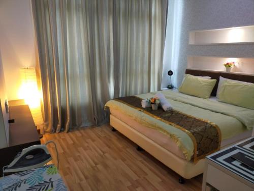 um quarto de hotel com uma cama grande e uma mesa em Shaftsbury Residence Cyberjaya Wifi, Netflix, Free Parking em Cyberjaya