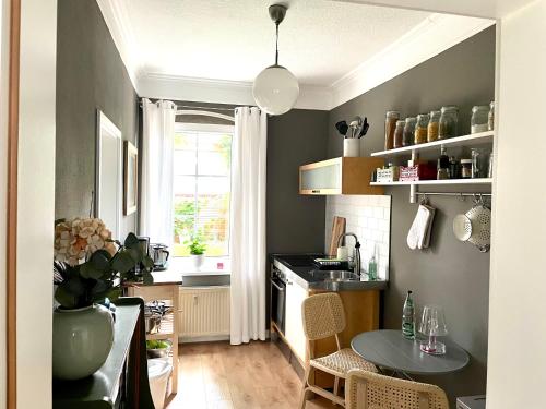 uma cozinha com uma mesa e uma pequena cozinha com uma janela em JETHON Appartement in der Gasse em Grimschleben