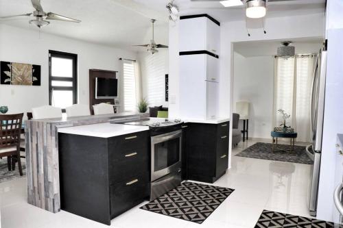 a kitchen with black and white appliances and a living room at Relaxing Property with Stunning Views and Pool in Toa Baja