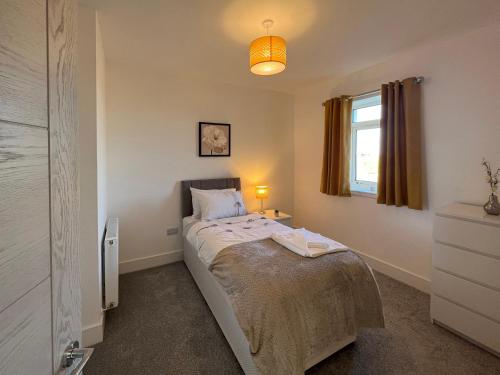 a small bedroom with a bed and a window at Dun Buidhe in Pollachar