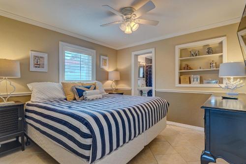 a bedroom with a bed and a ceiling fan at Bathing Suit Beach Bungalow in Ormond Beach