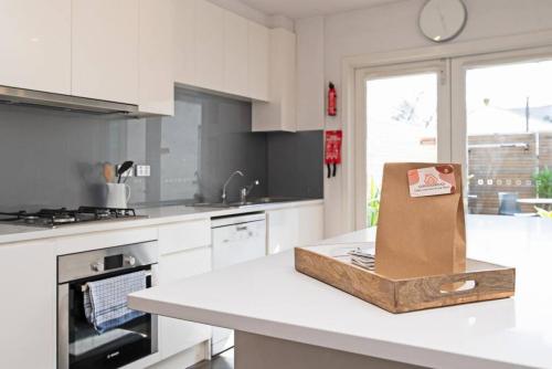 a white kitchen with a box on a counter at Character filled cottage in Norwood - Free wine in Adelaide