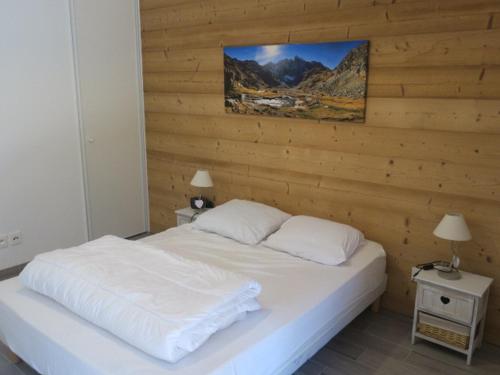 een bed met witte lakens en kussens in een slaapkamer bij Appartement Châtel, 2 pièces, 6 personnes - FR-1-198-147 in Châtel