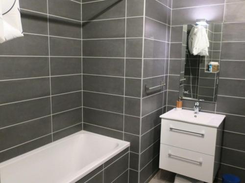 une salle de bain avec une baignoire et un lavabo dans l'établissement Chaleureux appartement 6 personnes avec balcon et parking - Châtel - FR-1-198-147, à Châtel