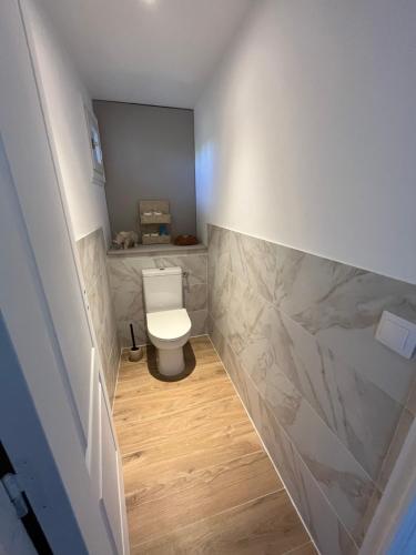 a bathroom with a white toilet and marble walls at Le Mas Justin in Gordes