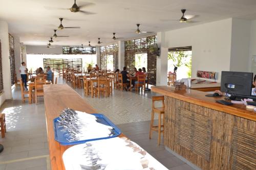 un restaurante con un bar con gente sentada en las mesas en Hotel Ranchería Campestre, en Sahagún