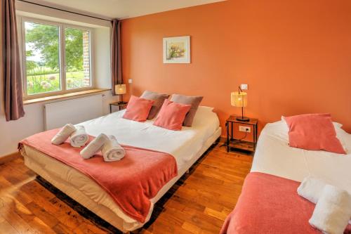 two beds in a room with orange walls at La Bergerie in Saint-Fargeau