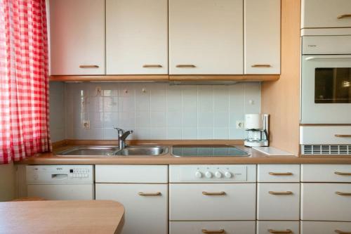 a kitchen with white cabinets and a sink at Natureview in Hamburg