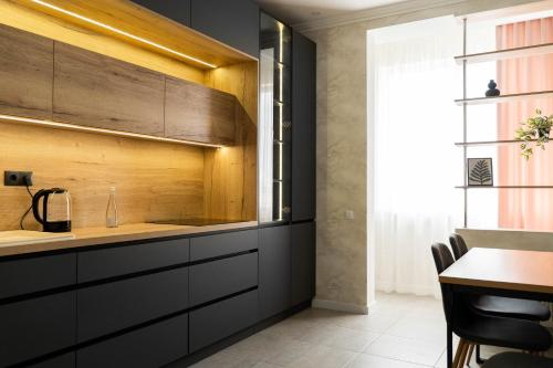 a kitchen with black cabinets and a table at RentWill apartments Gold in Chişinău