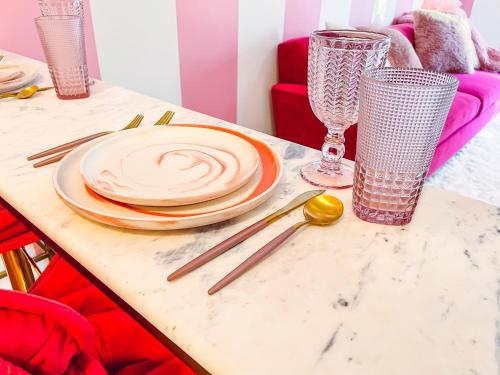 a table with plates and glasses on top of it at Dolly's Delight - Boutique Bliss Mins From Broadway in Nashville