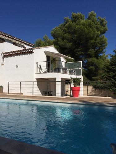 une maison avec une piscine devant une maison dans l'établissement Le petit cassis vue mer appartement 70m2 piscine, à Cassis