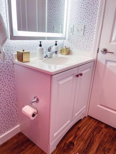 a pink bathroom with a sink and a mirror at Dolly's Delight - Boutique Bliss Mins From Broadway in Nashville