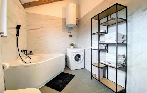 y baño con bañera y lavadora. en Nice Home In Vrgorac With Wifi, en Vrgorac