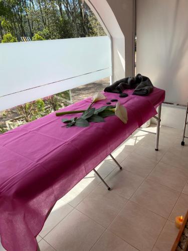 a purple blanket sitting on a bench in front of a window at La Posada De Los Arcángeles in Madrid