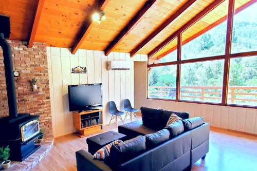a living room with a couch and a tv at Redwood Retreat, Mountains, Adventure and Nature in Ponderosa