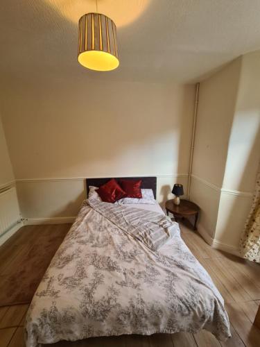 a bedroom with a bed with a comforter and a lamp at Ground floor flat , 31 lena street, easton,bristol avon, uk in Bristol