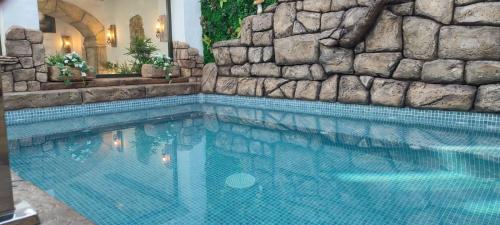 una gran piscina con una pared de piedra en El MANANTIAL, en Zahara de la Sierra