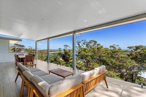 a living room with a couch and a table on a balcony at The Zenith in Shoal Bay