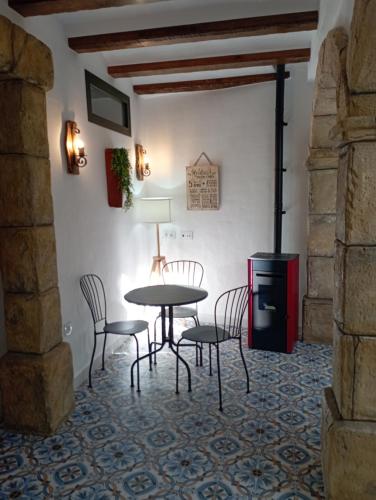 a dining room with a table and chairs and a stove at El MANANTIAL in Zahara de la Sierra