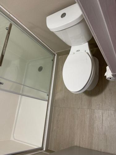 a bathroom with a toilet and a glass shower at Scottish Inns - Commerce in Commerce