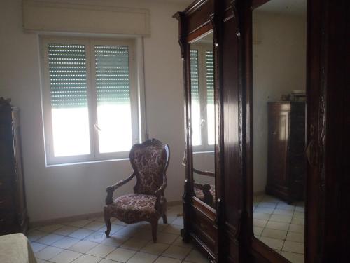 a chair sitting in a room with a mirror at Tana delle Sirene Cilento Coast Acciaroli Sea Pollica in Acciaroli