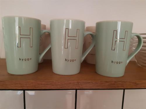 three coffee mugs sitting on top of a shelf at Hygge chaloupka v horách in Český Jiřetín