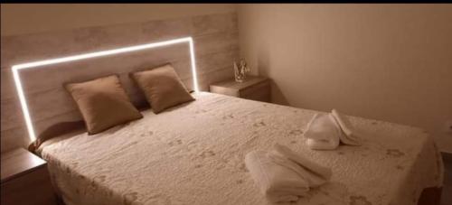 a bedroom with a white bed with two towels on it at Alojamento Silva in Castelo de Paiva