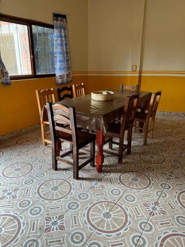 a dining room with a table and chairs on a carpet at LÍZU Tu casa en un pueblo zapoteca in Teotitlán del Valle