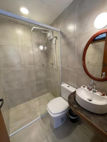 a bathroom with a shower and a toilet and a sink at Orlanova Hotel in Arraial do Cabo