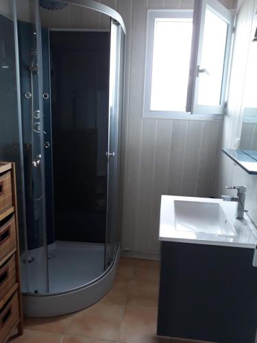 une salle de bain avec douche et lavabo dans l'établissement Maison entre Terre et Mer avec Jacuzzi, à Sauzon