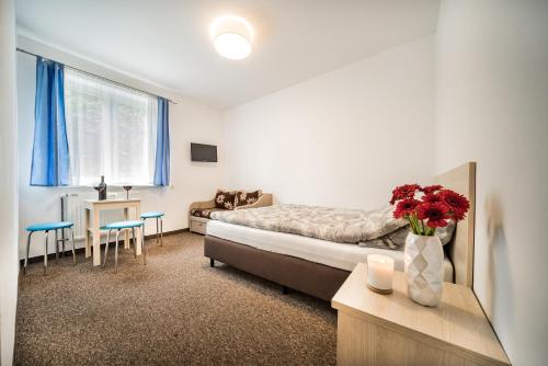 博格泽利卡ALBOPOGORZELICA, DOM GOŚCINNY的一间卧室，里面有一张床和一张摆着鲜花的桌子