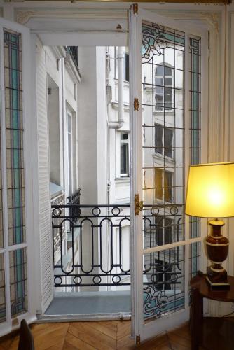 une porte donnant sur un balcon avec une fenêtre et une lampe. dans l'établissement Prestigious 2 bedroom near Champs Elysées, à Paris