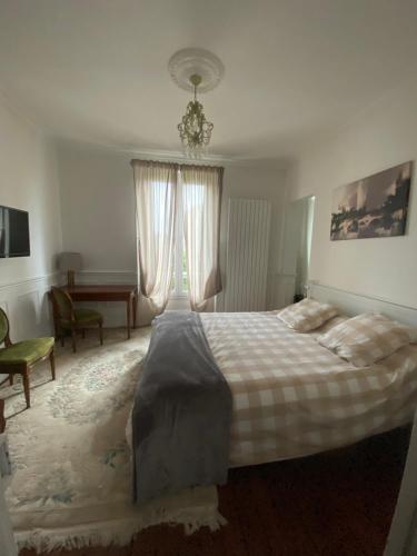 a bedroom with a bed and a desk and a window at Joffre in Fontainebleau