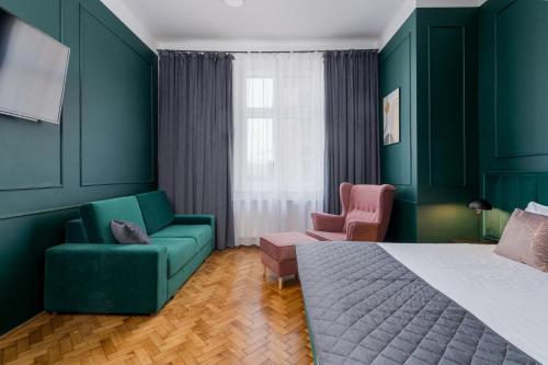ein Schlafzimmer mit grünen Wänden sowie einem Bett und Stühlen in der Unterkunft Wawel Boutique Residence - Krakow Old Town in Krakau