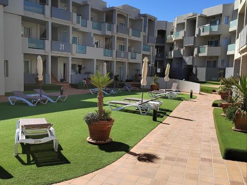 a courtyard of a apartment building with tables and chairs at Rizi Corralejo Sun in Corralejo