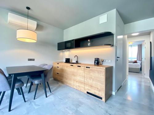 a kitchen with a sink and a table with chairs at H11 Aparthotel in Kraków