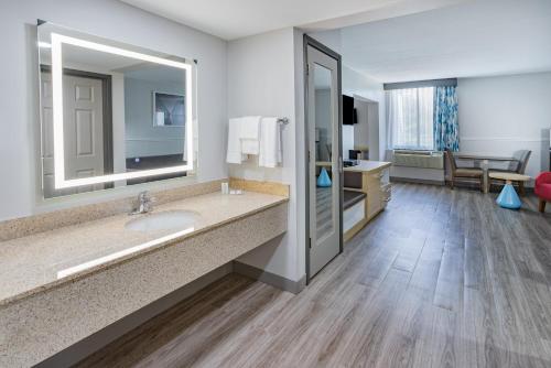 a bathroom with a sink and a large mirror at Wingate by Wyndham Fishkill in Fishkill