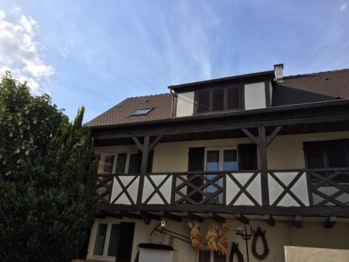 a building with a balcony on the side of it at Les Hibiscus in Andolsheim